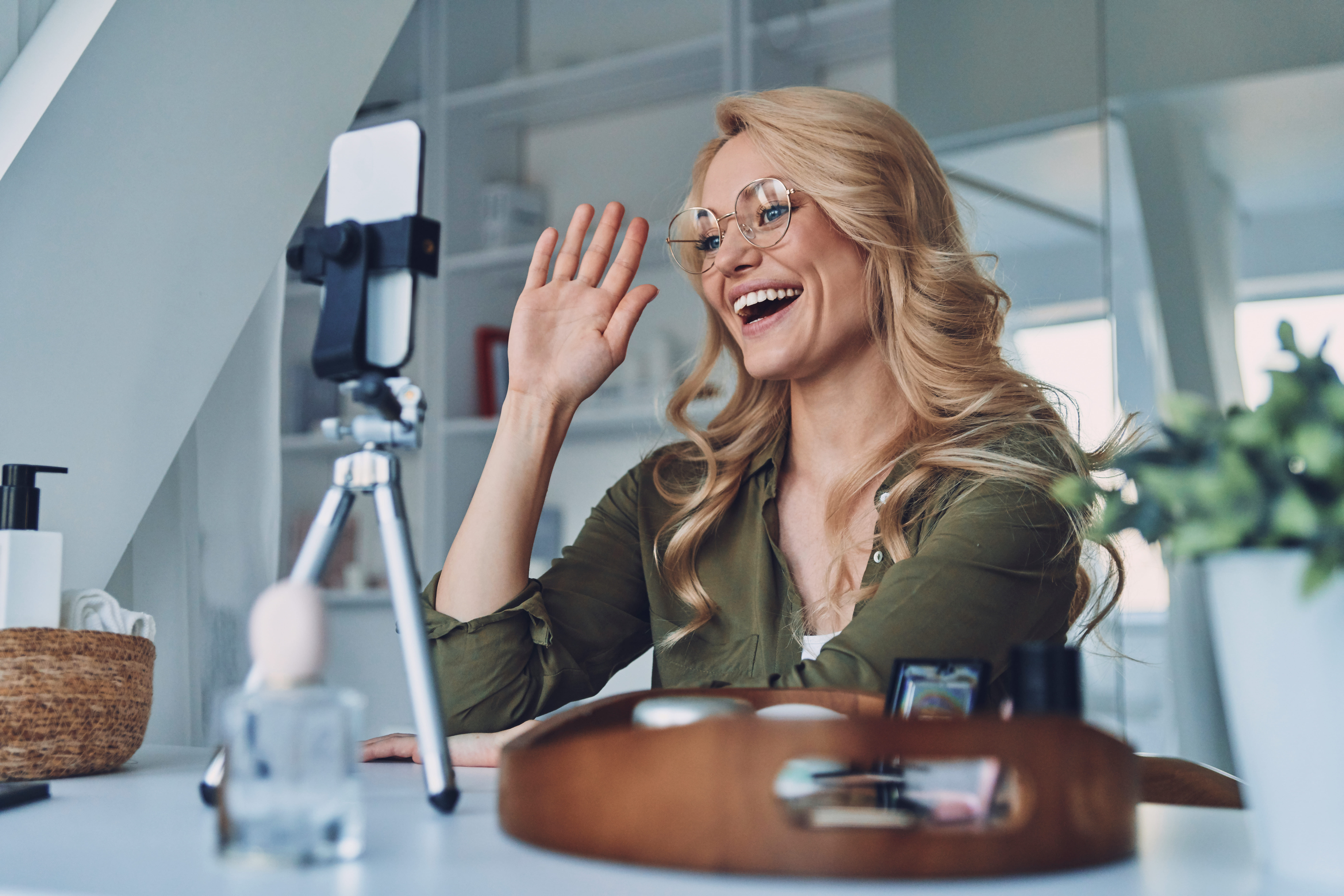 Smiling creator filming a product video on her smartphone
